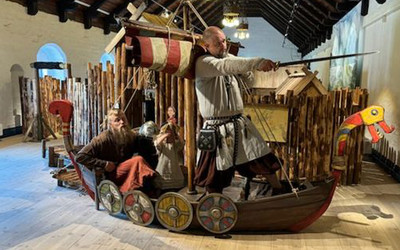 Vikingar i vikingaskepp i lekutställning