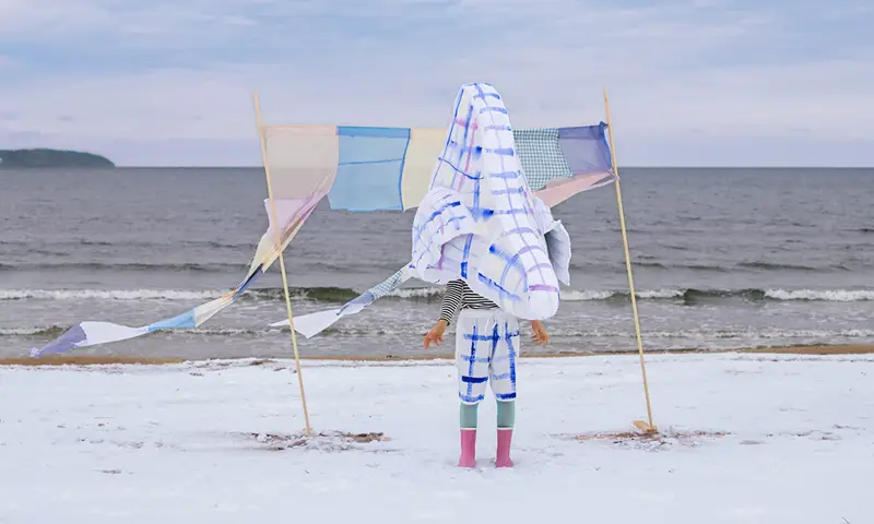 Gestalt med gigantisk näsa står på en strand